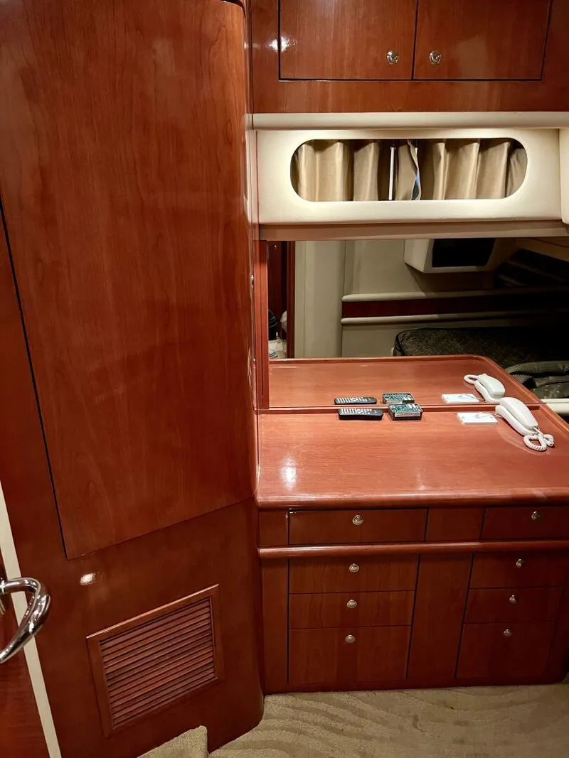 Slide: The Image of 2001 Sea Ray 56 Sedan Bridge interior cabin with wooden cabinetry and desk. - 16