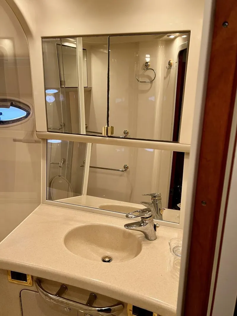 Slide: The Image of 2001 Sea Ray 56 Sedan Bridge bathroom with sink, mirror, and shower. - 20