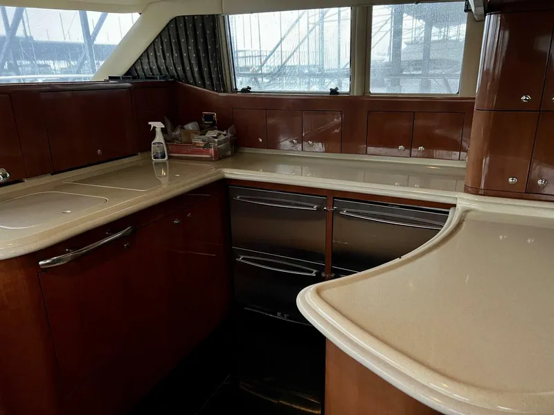 Slide: The Image of Interior kitchen of 2001 Sea Ray 56 Sedan Bridge yacht with wooden cabinets and modern appliances. - 4
