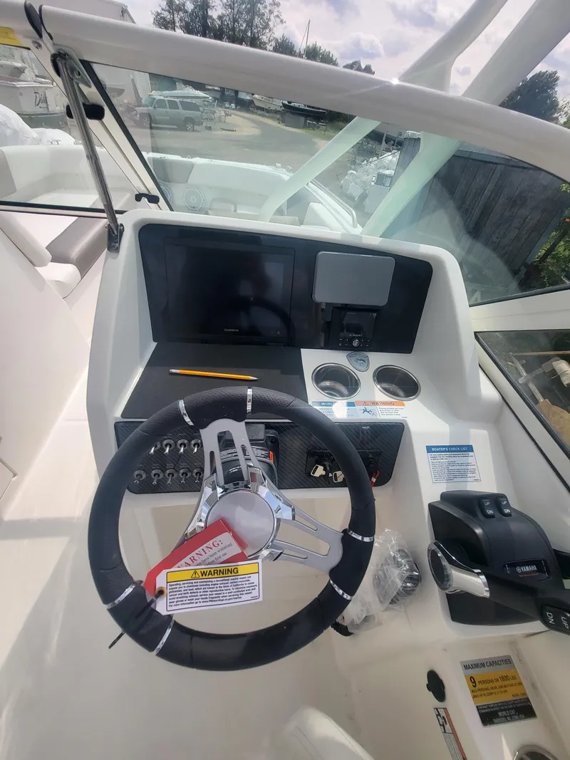 Slide: The Image of 2024 World Cat 230 SD boat dashboard with steering wheel and control panel. - 5