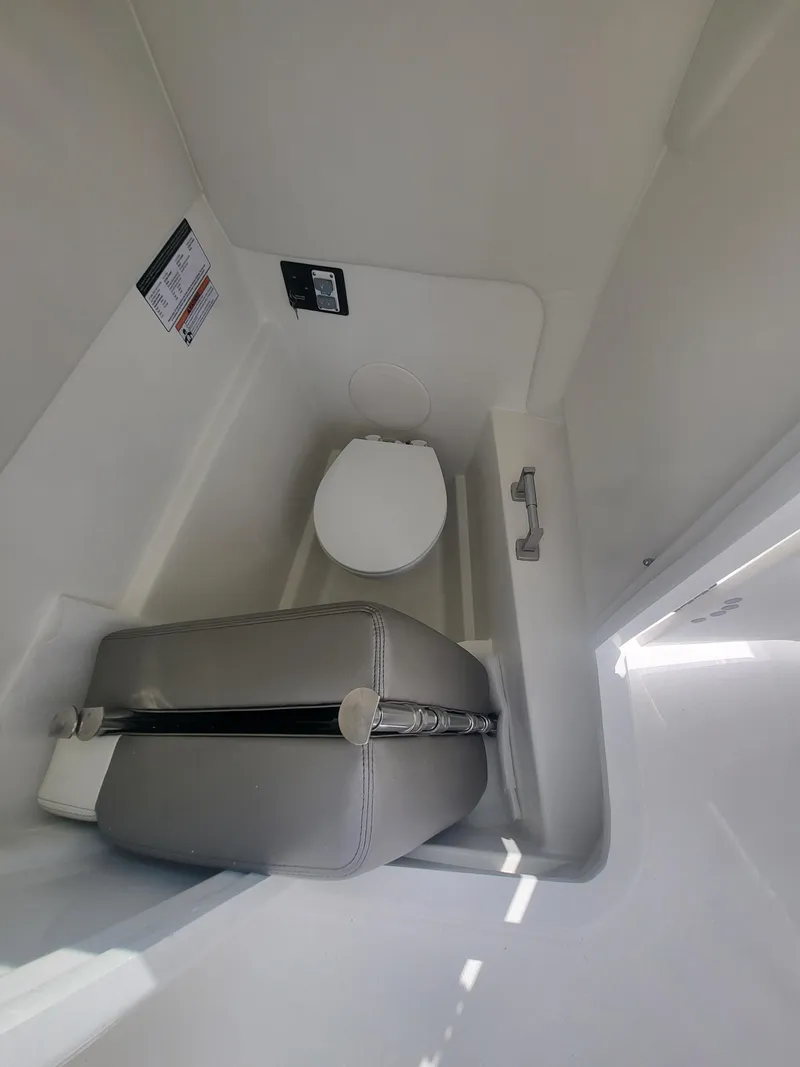Slide: The Image of 2024 World Cat 230 SD boat interior with compact toilet and cushioned seat. - 9