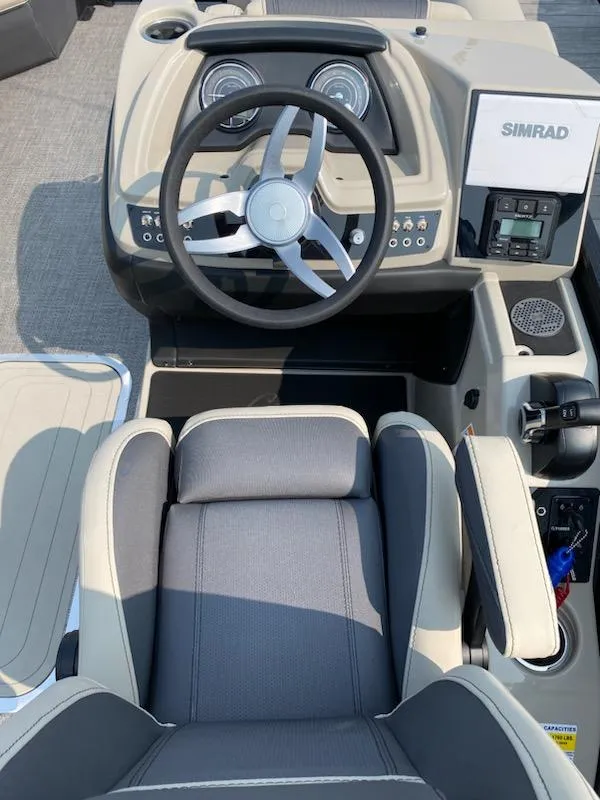 Slide: The Image of 2023 Barletta C22UC boat cockpit with steering wheel and Simrad display. - 3