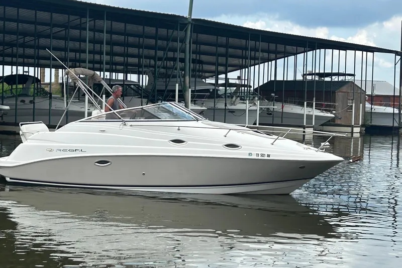 Slide: The Image of 2008 Regal 2665 Commodore boat interior with white seating and cup holders. - 24