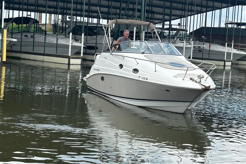 Slide: The Image of 2008 Regal 2665 Commodore boat docked, rear view with a person onboard. - 27