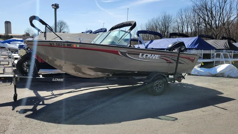 Slide: The Image of 2008 Lowe FS185 boat with Mercury 150 engine on trailer, parked outdoors. - 1
