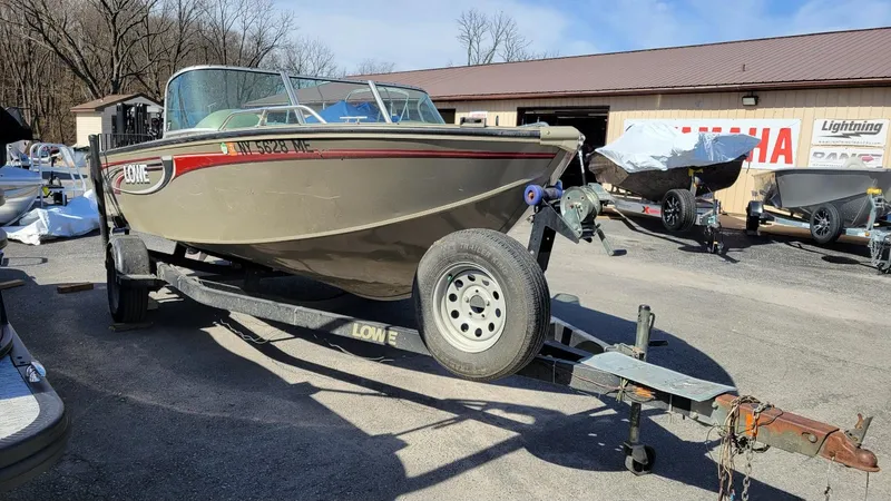 Slide: The Image of 2008 Lowe FS185 boat with Mercury 150 engine on trailer, parked outdoors. - 13