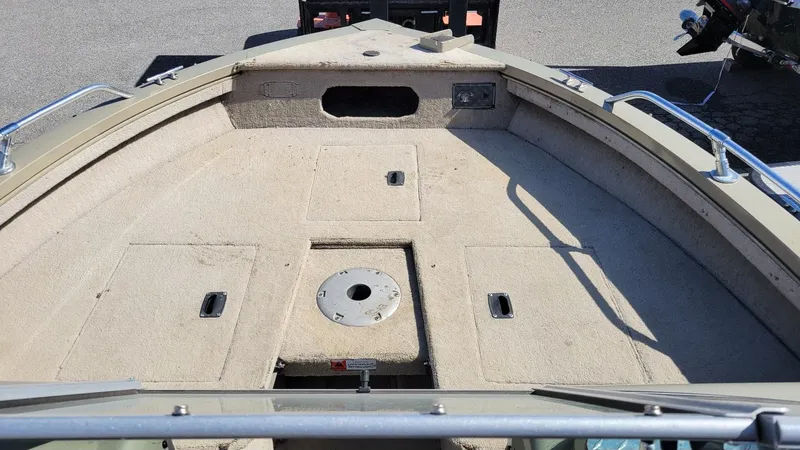 Slide: The Image of 2008 Lowe FS185 boat interior with walk-thru windshield, beige carpet, and storage compartments. - 16