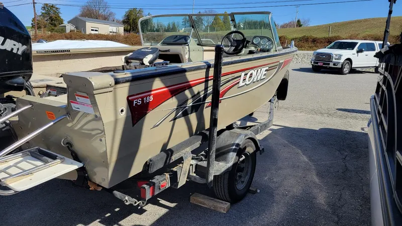 Slide: The Image of 2008 Lowe FS185 boat with Mercury 150 engine on trailer, parked outdoors. - 4