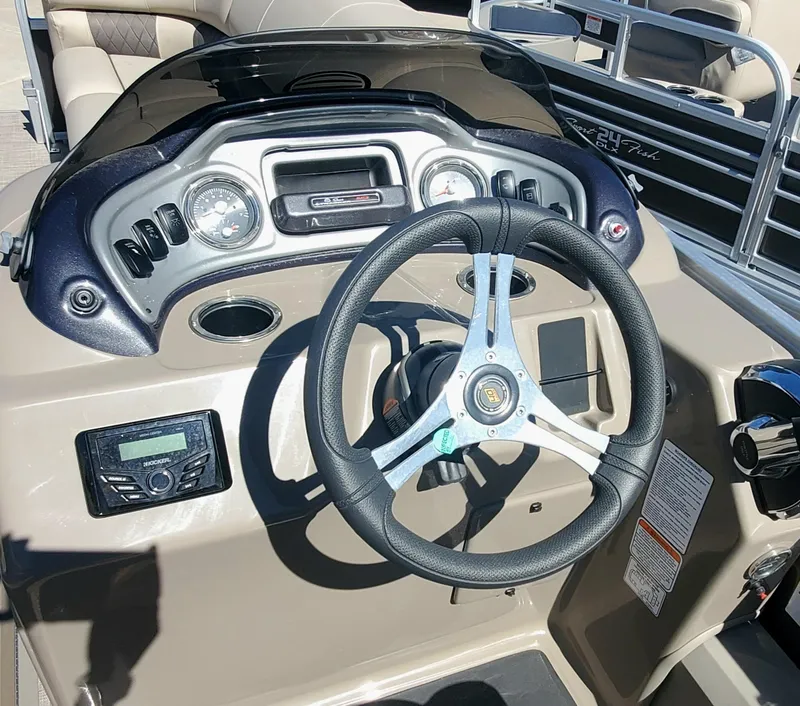 Slide: The Image of 2023 Sun Tracker SportFish 22 XP3 boat dashboard with steering wheel and control panel. - 3