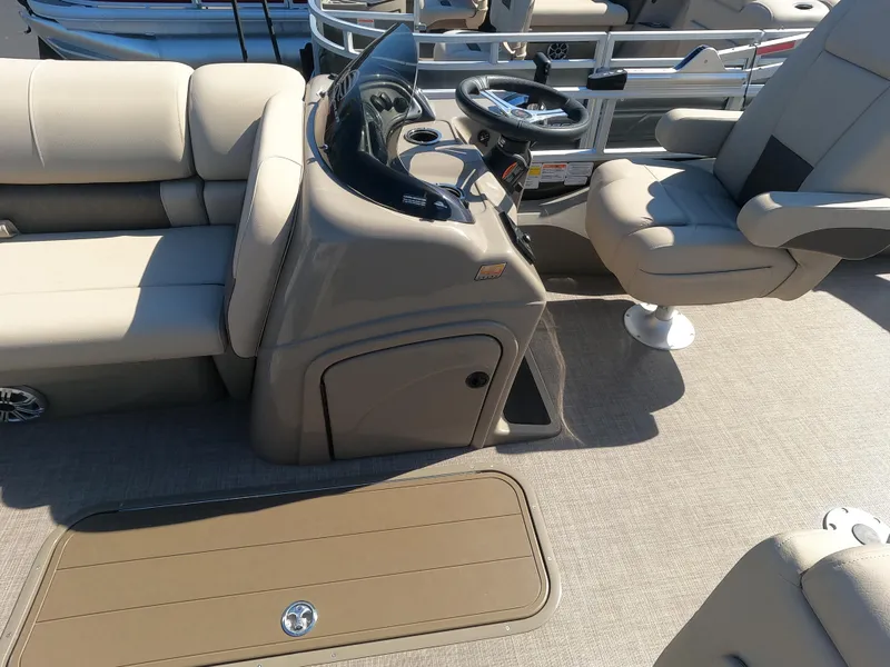 Slide: The Image of 2023 Sun Tracker SportFish 22 XP3 boat interior with beige seating and steering console. - 4