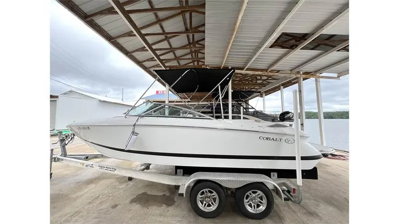 The Image of 2006 Cobalt 220 Bow boat on a trailer under a covered dock. - 1
