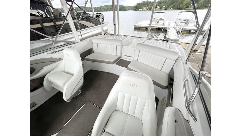 Slide: The Image of 2006 Cobalt 220 Bow boat interior with white leather seats docked at a marina. - 7