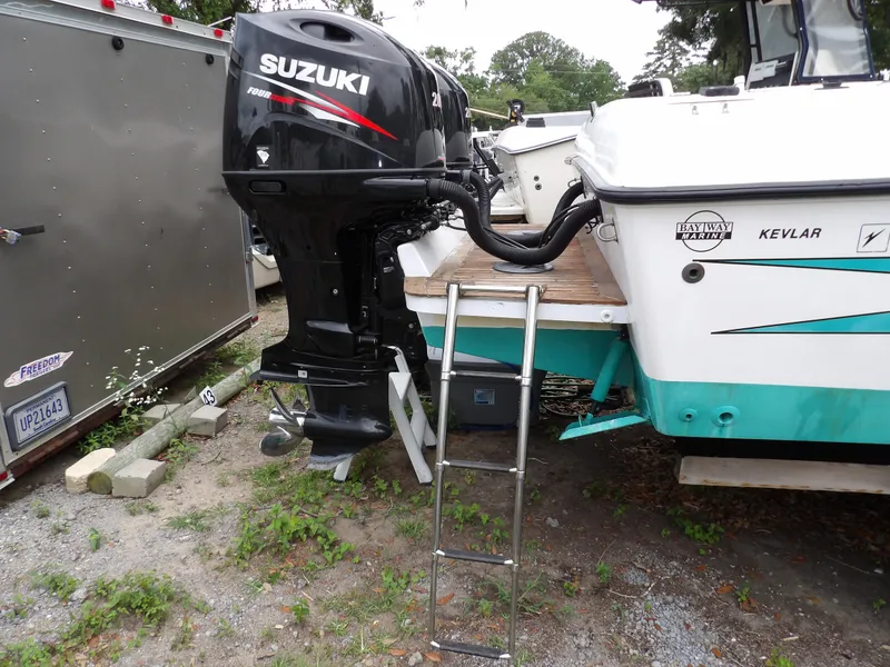 Slide: The Image of 1997 Hydra-Sports 2750 WA boat with Suzuki outboard motor and ladder on gravel surface. - 13