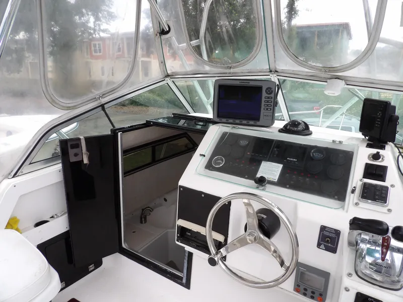 Slide: The Image of 1997 Hydra-Sports 2750 WA boat cockpit with steering wheel and navigation equipment. - 23