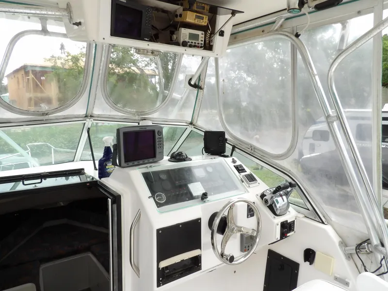 Slide: The Image of 1997 Hydra-Sports 2750 WA boat cockpit with steering wheel and navigation equipment. - 24