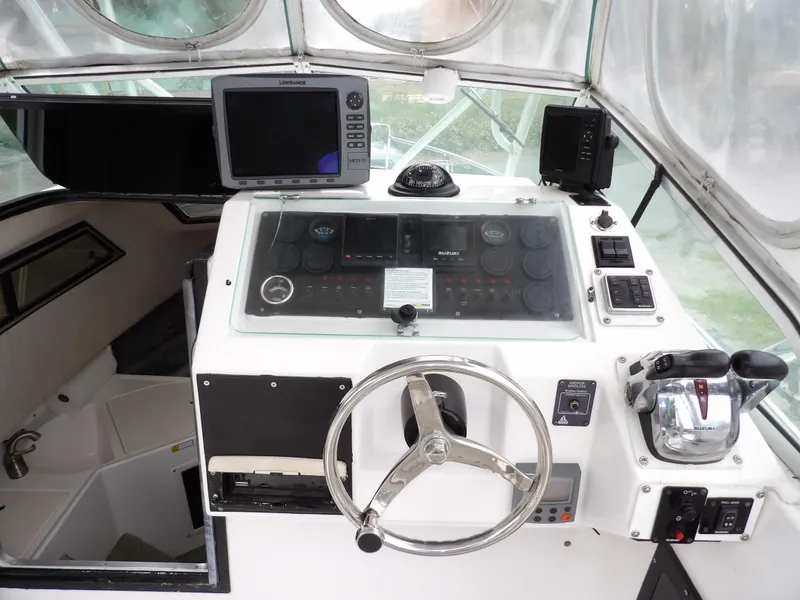 Slide: The Image of 1997 Hydra-Sports 2750 WA boat cockpit with steering wheel and navigation equipment. - 25