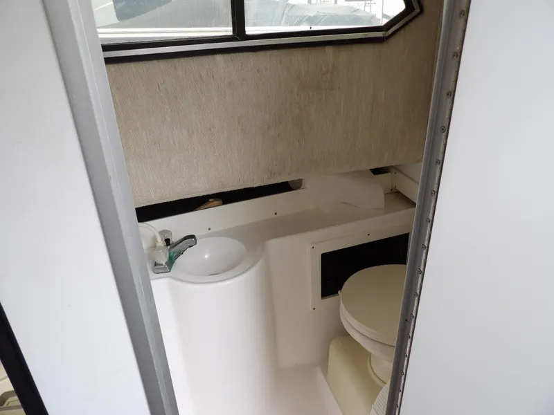 Slide: The Image of 1997 Hydra-Sports 2750 WA boat interior bathroom with sink and toilet. - 33