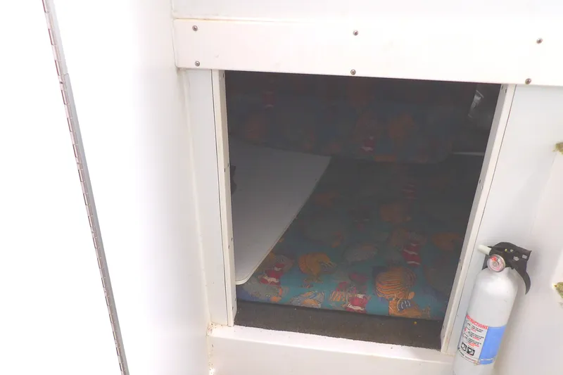 Slide: The Image of 1997 Hydra-Sports 2750 WA cabin interior with colorful bedding and fire extinguisher. - 34