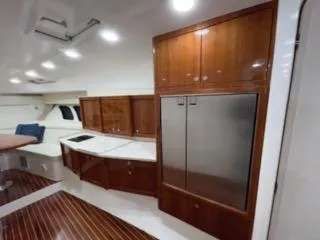 Slide: The Image of 2017 Intrepid 475 Sport Yacht interior with wooden cabinetry and stainless steel appliances. - 10