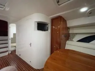 Slide: The Image of Interior of 2017 Intrepid 475 Sport Yacht with wooden table and TV. - 11