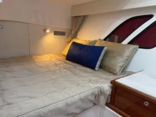 Slide: The Image of 2017 Intrepid 475 Sport Yacht cabin with cozy bed and ambient lighting. - 13