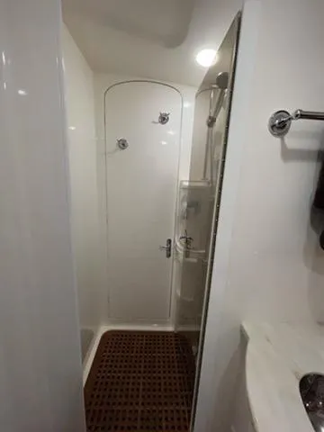 Slide: The Image of 2017 Intrepid 475 Sport Yacht bathroom with shower and wooden floor mat. - 14