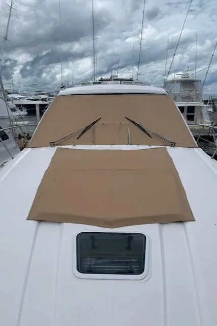 Slide: The Image of 2015 Regal 42 Sport Coupe yacht with tan covers docked at marina. - 11