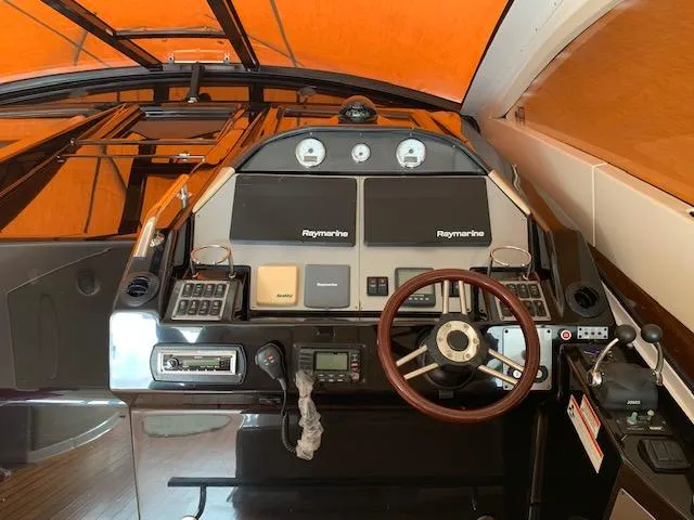 Slide: The Image of 2015 Regal 42 Sport Coupe helm with Raymarine electronics and wooden steering wheel. - 12