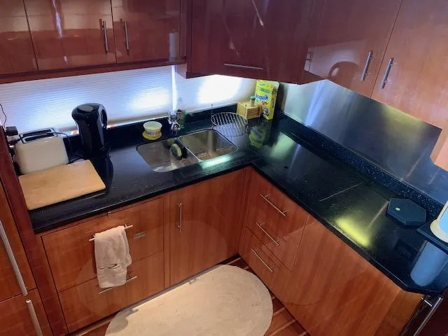 Slide: The Image of Modern kitchen in 2015 Regal 42 Sport Coupe yacht with black countertops. - 19