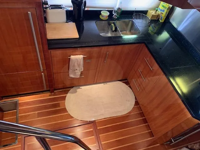 Slide: The Image of 2015 Regal 42 Sport Coupe kitchen with wooden cabinets and black countertops. - 20