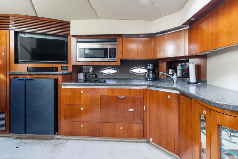 Slide: The Image of 2007 Cruisers Yachts 520 Express kitchen with modern appliances and wooden cabinetry. - 4