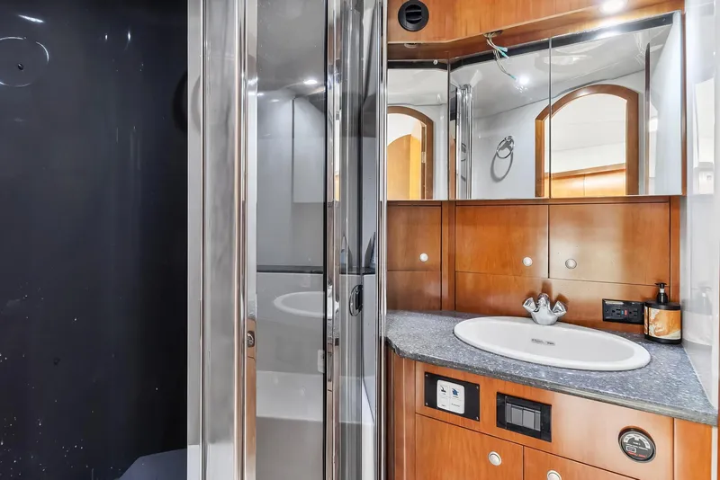 Slide: The Image of 2007 Cruisers Yachts 520 Express bathroom with modern fixtures and wooden cabinetry. - 12