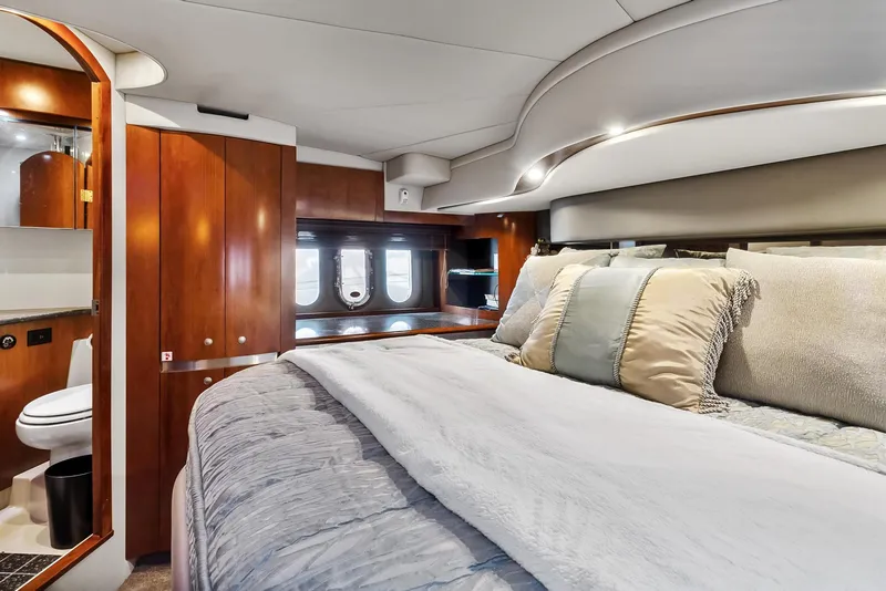 Slide: The Image of Luxurious bedroom interior of 2007 Cruisers Yachts 520 Express with plush bedding and wooden cabinetry. - 2