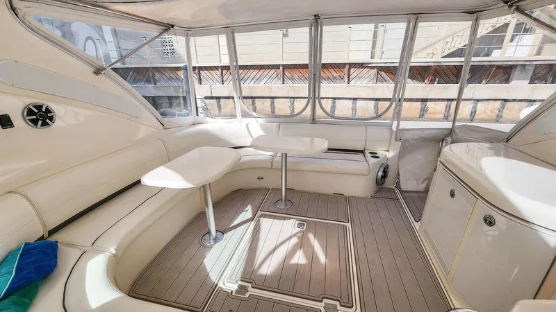 Slide: The Image of 2007 Cruisers Yachts 520 Express interior with seating and tables in enclosed deck area. - 27