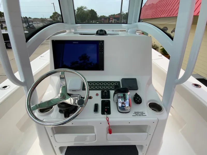 Slide: The Image of 2021 Blue Wave 2800 Makaira boat console with steering wheel and navigation system. - 16