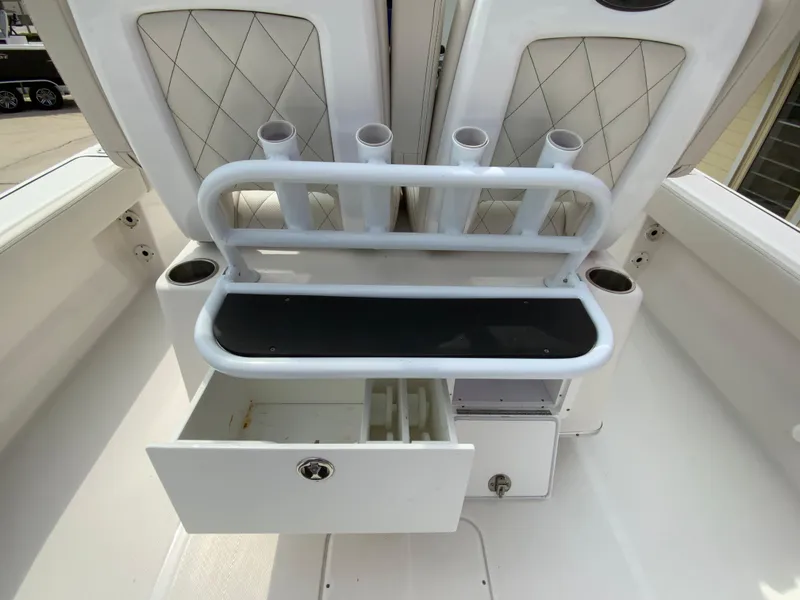 Slide: The Image of 2021 Blue Wave 2800 Makaira boat interior with rod holders and storage drawer. - 18