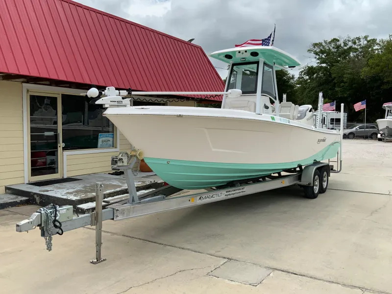 Slide: The Image of 2021 Blue Wave 2800 Makaira boat on a trailer outside a building with a red roof. - 6