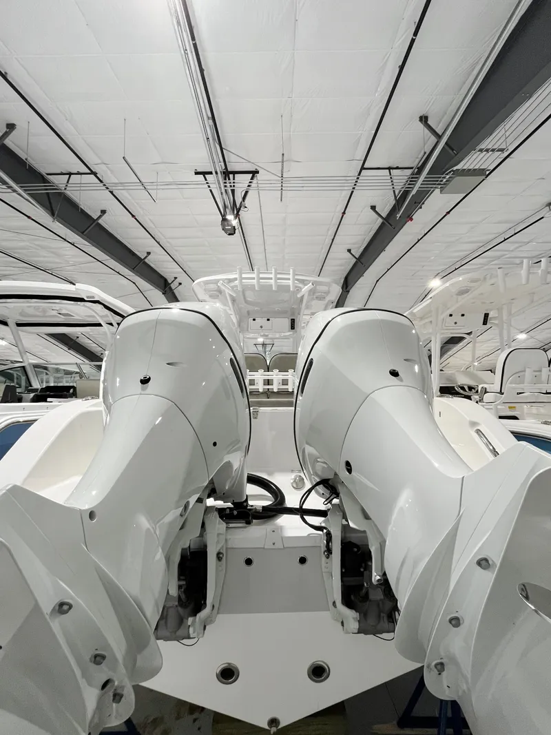 Slide: The Image of 2024 Sea Pro 262CC boat with dual outboard engines in a showroom. - 9