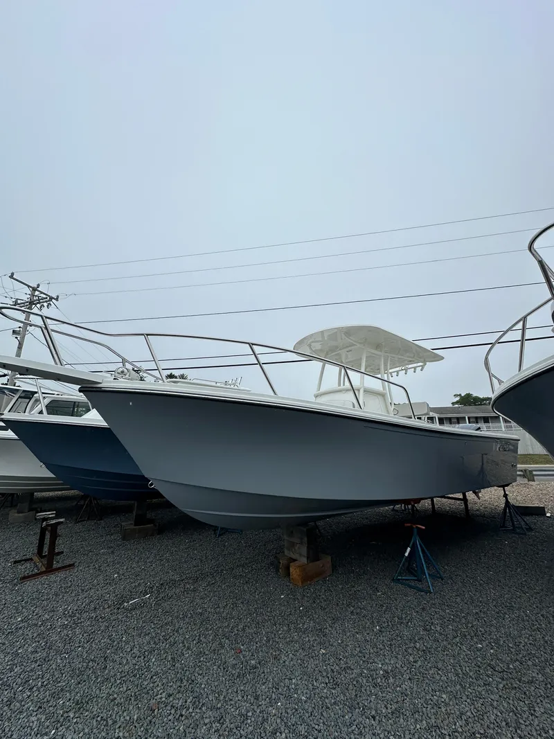 Slide: The Image of 2023 Parker 2500 Special Edition boat on display in a gravel lot. - 2