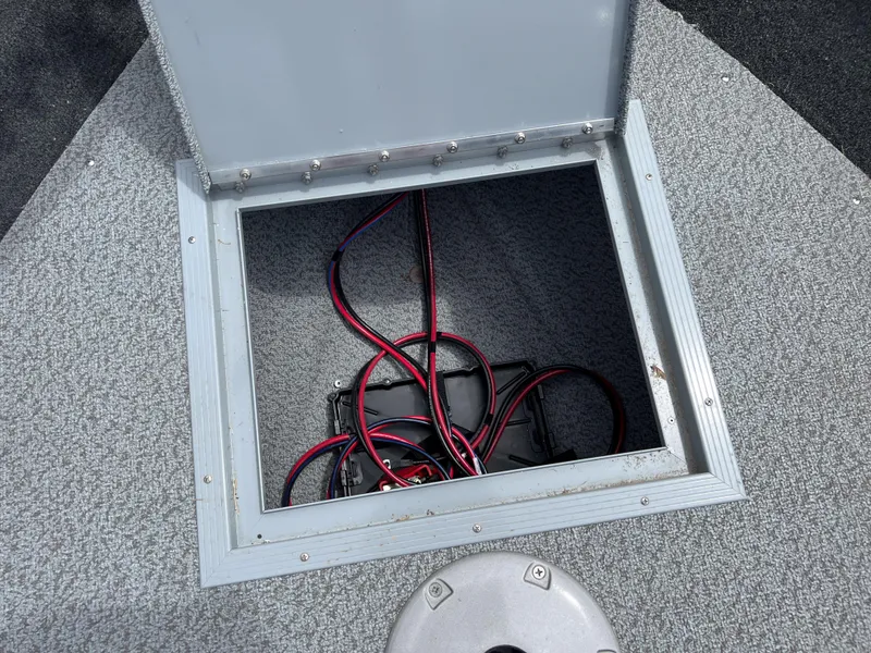 Slide: The Image of Open storage compartment with wiring in a 2023 Starcraft Stealth 166 DC boat. - 12