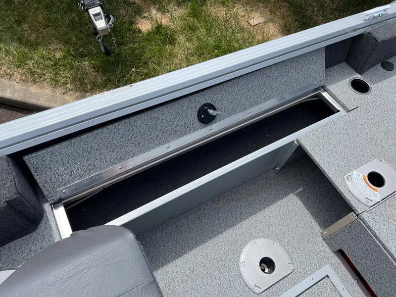 Slide: The Image of 2023 Starcraft Stealth 166 DC boat interior with storage compartment and seating. - 7