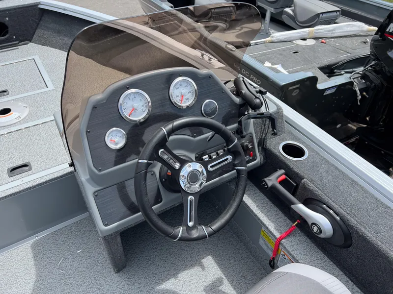 Slide: The Image of 2023 Starcraft Stealth 166 DC boat dashboard with steering wheel and gauges. - 9