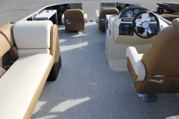 Slide: The Image of 2023 Lowe SF212 pontoon boat interior with beige and brown seating, modern dashboard, and spacious layout. - 4