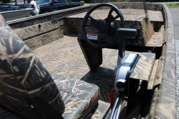 Slide: The Image of 2023 Lowe RX 2070 SC boat interior with camouflage design and steering console. - 2