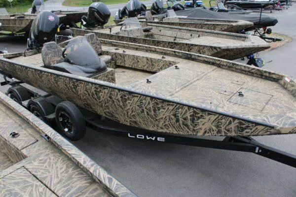Slide: The Image of 2023 Lowe CAT 20 camo fishing boats lined up on trailers. - 7