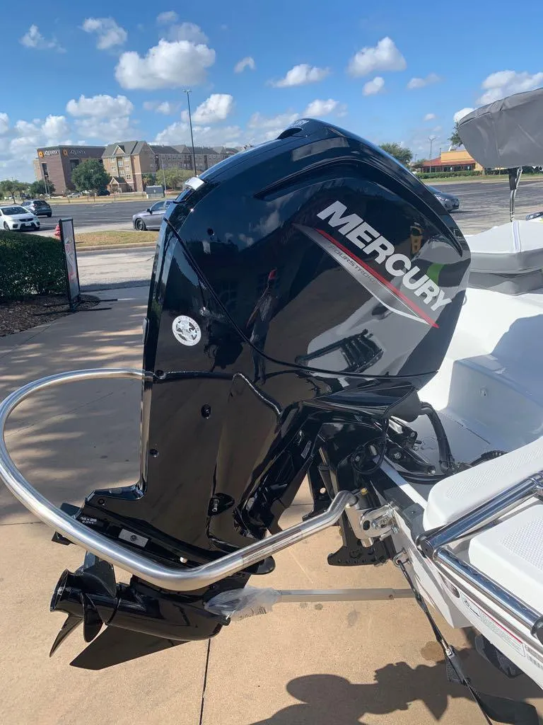 Slide: The Image of 2023 Tahoe T16 boat with Mercury outboard motor, parked outdoors under a clear sky. - 2