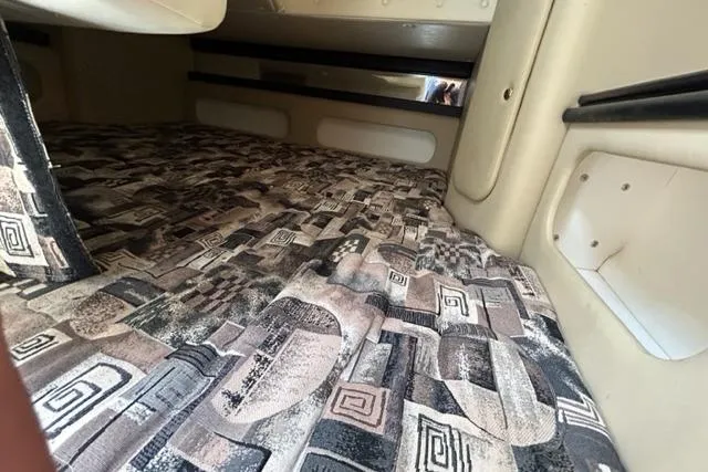 Slide: The Image of 2003 Rinker 290 Fiesta Vee cabin interior with patterned bedding. - 10