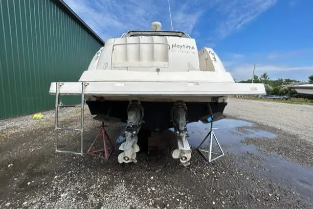 Slide: The Image of 2003 Rinker 290 Fiesta Vee boat on dry land, rear view with dual propellers. - 23