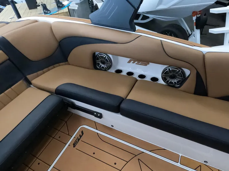 Slide: The Image of 2023 MB B52 Alpha boat interior with tan and black seating, speakers, and cup holders. - 12