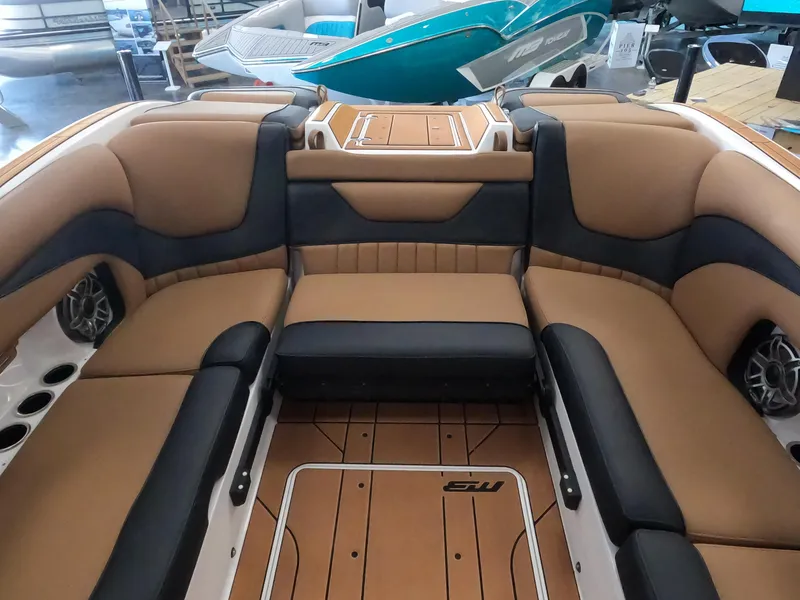 Slide: The Image of 2023 MB B52 Alpha boat interior with tan and black seating, cup holders, and speakers. - 13